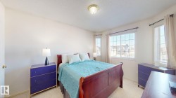 Bedroom featuring a textured ceiling and light colored carpet - 