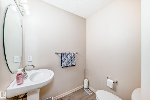 Half bath featuring baseboards and wood finished floors - 1285 Cunningham Drive, Edmonton, AB - Indoor Photo Showing Bathroom