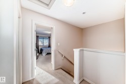 Hallway with an upstairs landing and light colored carpet - 