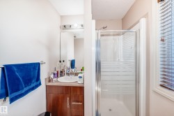 Full bath featuring a shower stall, vanity, and a textured ceiling - 
