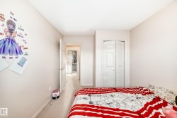 Carpeted bedroom with baseboards and a closet - 