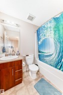 Bathroom featuring light tile patterned flooring, vanity, shower / bathtub combination with curtain, and a textured ceiling - 
