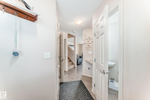 Hall featuring a textured ceiling, stairway, and light wood-type flooring - 1285 Cunningham Drive, Edmonton, AB - Indoor Photo Showing Other Room
