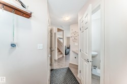 Hall featuring a textured ceiling, stairway, and light wood-type flooring - 