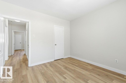 Unfurnished bedroom with light wood-style floors and baseboards - 10704 96 St Nw, Edmonton, AB - Indoor Photo Showing Other Room