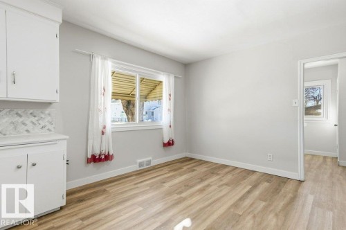 Unfurnished dining area featuring light wood-style floors - 10704 96 St Nw, Edmonton, AB - Indoor Photo Showing Other Room