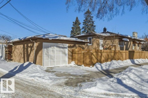 View of snowy exterior with an outdoor structure, a chimney, and a garage - 10704 96 St Nw, Edmonton, AB - Outdoor