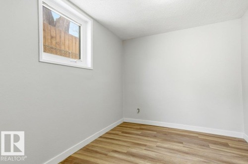 Spare room featuring light wood-style floors and a textured ceiling - 10704 96 St Nw, Edmonton, AB - Indoor Photo Showing Other Room