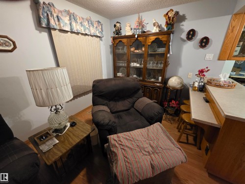 Sitting room featuring a textured ceiling and wood finished floors - 4400 45 Avenue, Stony Plain, AB - Indoor