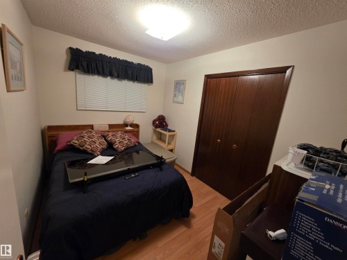 Bedroom with a closet, light wood-style flooring, and a textured ceiling - 4400 45 Avenue, Stony Plain, AB - Indoor Photo Showing Bedroom