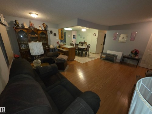Living room with wood finished floors, a textured ceiling, and a ceiling fan - 4400 45 Avenue, Stony Plain, AB - Indoor Photo Showing Living Room