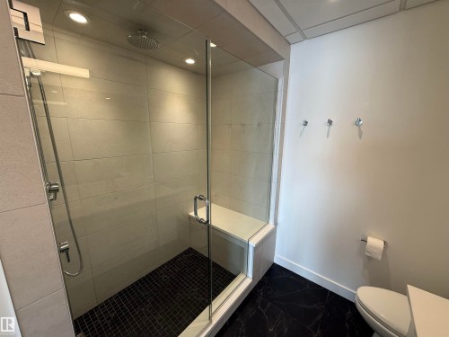 Bathroom with a shower stall, dark marble finish floors, and recessed lighting - 605 8728 Gateway Boulevard, Edmonton, AB - Indoor Photo Showing Bathroom
