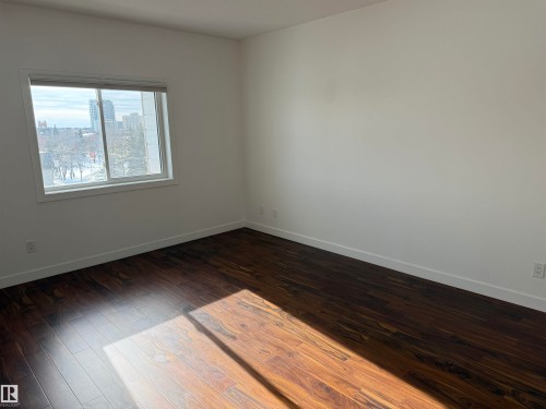 Spare room with dark wood-style floors and a view of city - 605 8728 Gateway Boulevard, Edmonton, AB - Indoor Photo Showing Other Room