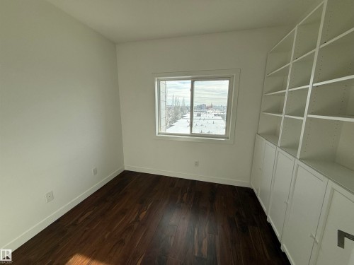 Empty room featuring dark wood finished floors and baseboards - 605 8728 Gateway Boulevard, Edmonton, AB - Indoor Photo Showing Other Room