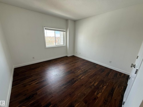 Spare room featuring dark wood-style flooring and a textured ceiling - 605 8728 Gateway Boulevard, Edmonton, AB - Indoor Photo Showing Other Room