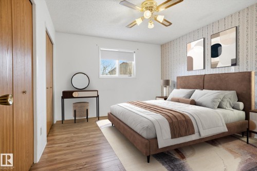 Bedroom featuring wood finished floors, two closets, ceiling fan, a textured ceiling, and wallpapered walls - 17816 94 Street, Edmonton, AB - Indoor Photo Showing Bedroom