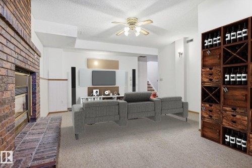 Living area with a fireplace, a ceiling fan, carpet floors, and a textured ceiling - 17816 94 Street, Edmonton, AB - Indoor With Fireplace