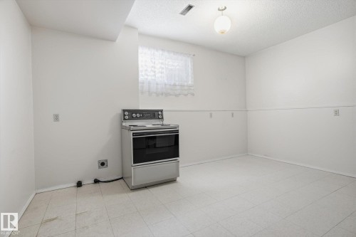 Kitchen featuring electric stove, a textured ceiling, and light flooring - 17816 94 Street, Edmonton, AB - Indoor