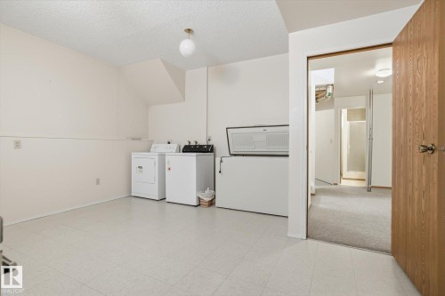 Laundry area with washing machine and clothes dryer, a textured ceiling, and light flooring - 17816 94 Street, Edmonton, AB - Indoor Photo Showing Laundry Room
