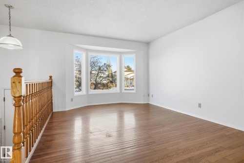Empty room with dark wood-type flooring and a textured ceiling - 17816 94 Street, Edmonton, AB - Indoor Photo Showing Other Room