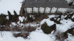 Snowy aerial view featuring a view of apartment building / complex - 