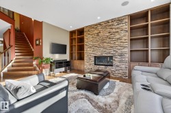 Living room with built in shelves, wood finished floors, a fireplace, a textured ceiling, and recessed lighting - 