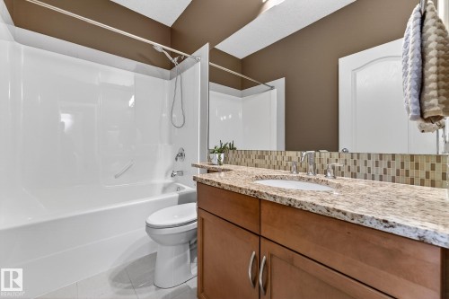 Full bathroom with vanity, backsplash, shower / bathtub combination, and light tile patterned flooring - 2036 Hilliard Place, Edmonton, AB - Indoor Photo Showing Bathroom