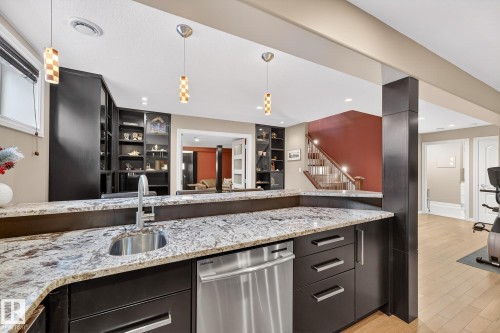 Kitchen featuring dishwasher, pendant lighting, light stone counters, and light wood-style floors - 2036 Hilliard Place, Edmonton, AB - Indoor Photo Showing Kitchen With Upgraded Kitchen