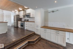 Kitchen featuring wood counters, backsplash, stainless steel appliances, wooden ceiling, and crown molding - 