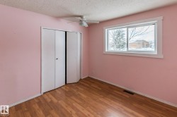 Unfurnished bedroom with wood finished floors, a closet, a textured ceiling, and a ceiling fan - 