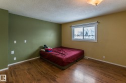 Bedroom featuring dark wood-style flooring and a textured ceiling - 
