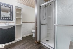 Bathroom with vanity, a stall shower, dark wood-style floors, a wainscoted wall, and wooden ceiling - 