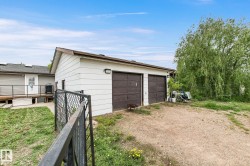 Detached two-car garage with white siding and brown garage doors - 