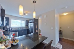 Kitchen featuring a peninsula, stainless steel appliances, pendant lighting, dark wood-style flooring, and a breakfast bar area - 