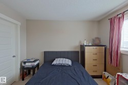 Bedroom with light colored carpet and a textured ceiling - 