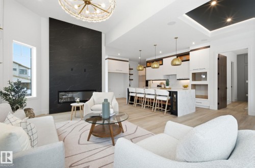 Living area with light wood-style floors, a chandelier, and a high end fireplace - 296 165 Avenue, Edmonton, AB - Indoor Photo Showing Living Room