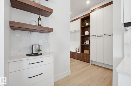Bar with open shelves, light wood-style flooring, dual tone cabinetry, modern cabinets, and tasteful backsplash - 296 165 Avenue, Edmonton, AB - Indoor Photo Showing Other Room