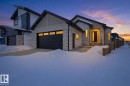 Contemporary house featuring stone siding, an attached garage, and stucco siding - 296 165 Avenue, Edmonton, AB  - Outdoor 