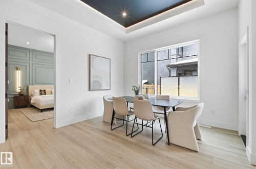 Dining area with a tray ceiling, light wood-style flooring, and recessed lighting - 296 165 Avenue, Edmonton, AB - Indoor Photo Showing Dining Room