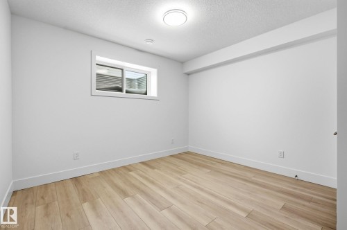 Unfurnished room featuring a textured ceiling and light wood finished floors - 296 165 Avenue, Edmonton, AB - Indoor Photo Showing Other Room