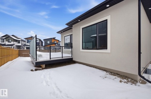 Snowy yard with a residential view and a deck - 296 165 Avenue, Edmonton, AB - Outdoor With Exterior