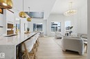 Kitchen with white cabinetry, a breakfast bar, light wood-style floors, open floor plan, and light stone counters - 296 165 Avenue, Edmonton, AB  - Indoor 