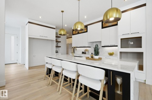 Dual tone kitchen with open shelves, a breakfast bar area, dual tone cabinetry, pendant lighting, and light stone countertops - 296 165 Avenue, Edmonton, AB - Indoor Photo Showing Dining Room