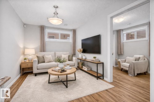 Living area featuring wood finished floors and a textured ceiling - 10639 70 Avenue, Edmonton, AB - Indoor Photo Showing Living Room