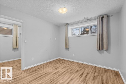 Unfurnished room with a textured ceiling and light wood finished floors - 10639 70 Avenue, Edmonton, AB - Indoor Photo Showing Other Room