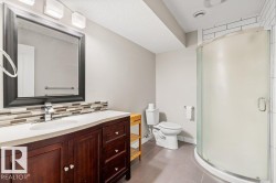 Full bathroom with dark tile patterned flooring, vanity, a shower stall, decorative backsplash, and a textured ceiling - 