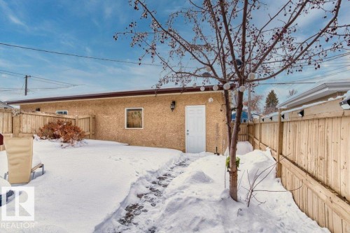 Snow covered back of property featuring a fenced backyard and stucco siding - 10639 70 Avenue, Edmonton, AB - Outdoor