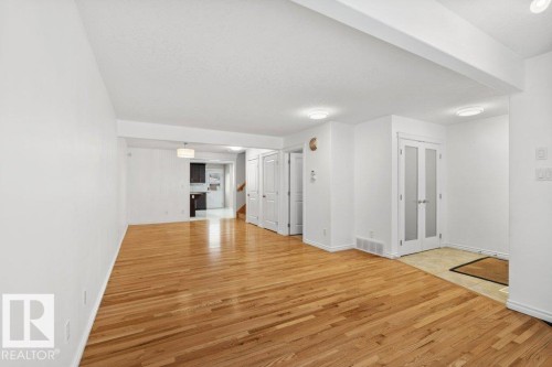 Unfurnished living room with light wood-style flooring - 10639 70 Avenue, Edmonton, AB - Indoor Photo Showing Other Room