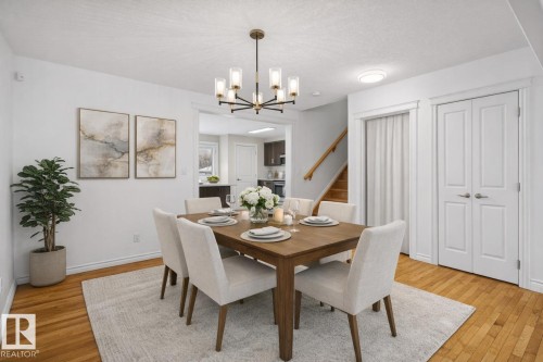 Dining room featuring hanging lights, light wood-style floors, and a textured ceiling - 10639 70 Avenue, Edmonton, AB - Indoor Photo Showing Dining Room