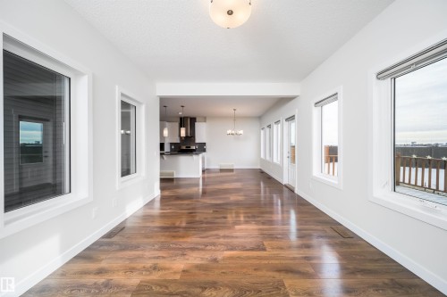 Hall with suspended lighting and dark wood-type flooring - 19743 26 Avenue, Edmonton, AB - Indoor Photo Showing Other Room